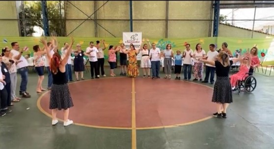 Grupo de alunos, professores e funcionários da Escola Metodista O Semeador, além de um cachorro, usando trajes temáticos da Celebração de Natal.